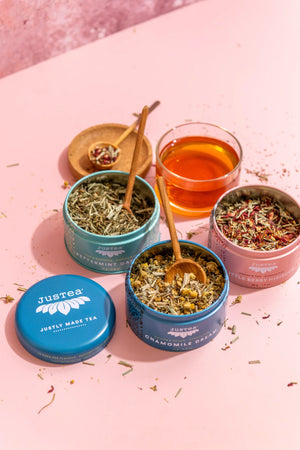 Justea Herbal Tea Trio beside glass of tea