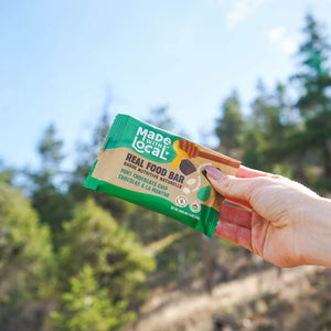 Mint chocolate chip real food bar Made with Local in woman's hand