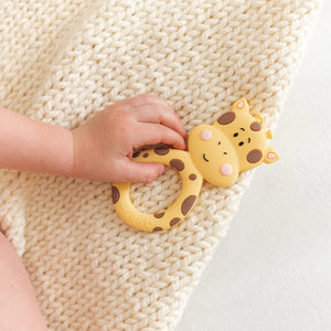 Little Cheeks Giraffe Silicone Teether in baby's hand