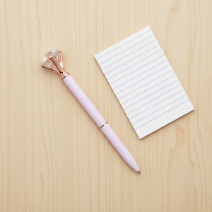 pink pen with gem beside notepad