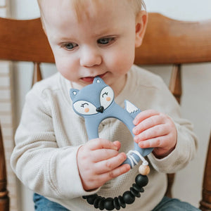Baby holding blue fox silicone teether