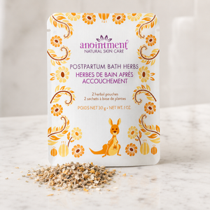 Anointment postpartum bath herbs on counter with herbs sprinkled in front of package