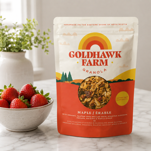Goldhawk Farm maple granola on counter with bowl of strawberries