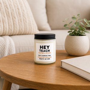 Hey Teach Candle Pretty by Her on coffee table