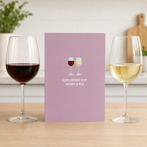 Birthday Partner in Wine Classy Cards on table between wine glasses