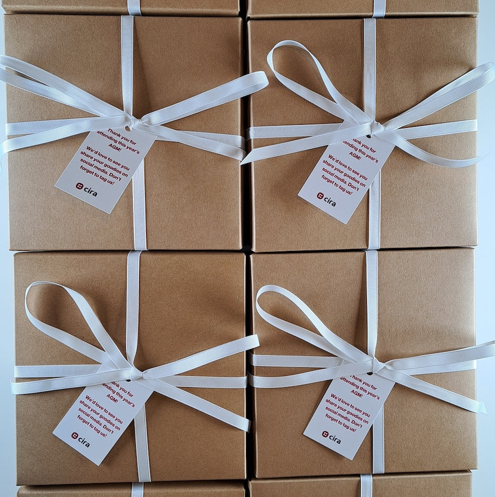 Kraft corporate gift boxes tied with white ribbon and custom branded tags for bulk corporate gifting in Canada