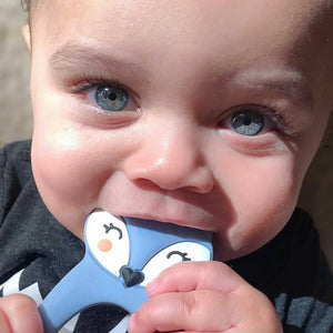 Closeup of baby holding blue fox silicone teether