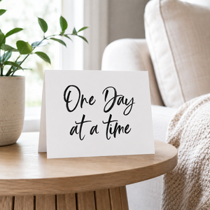 One Day at a Time card Pretty by Her on side table beside couch