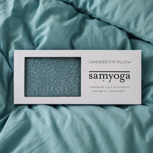 Samyoga breeze lavender eye pillow on teal comforter on bed