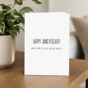 Stevie and Bean Happy Anniversary card on end table beside plant