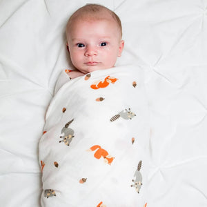 Lulujo Forest Friends Swaddle Blanket wrapped around baby