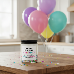 Happy Fucking Birthday Candle Pretty by Her on table with balloons in background