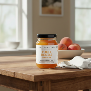 Provisions peach and prosecco sparkling jam on kitchen table with peaches
