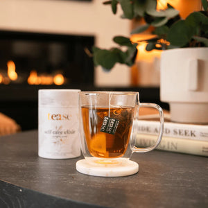 Tease Self Care Elixir beind glass mug