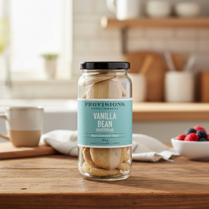 Provisions Vanilla Bean Shortbread Cookie Jar on kitchen table with fruit and coffee